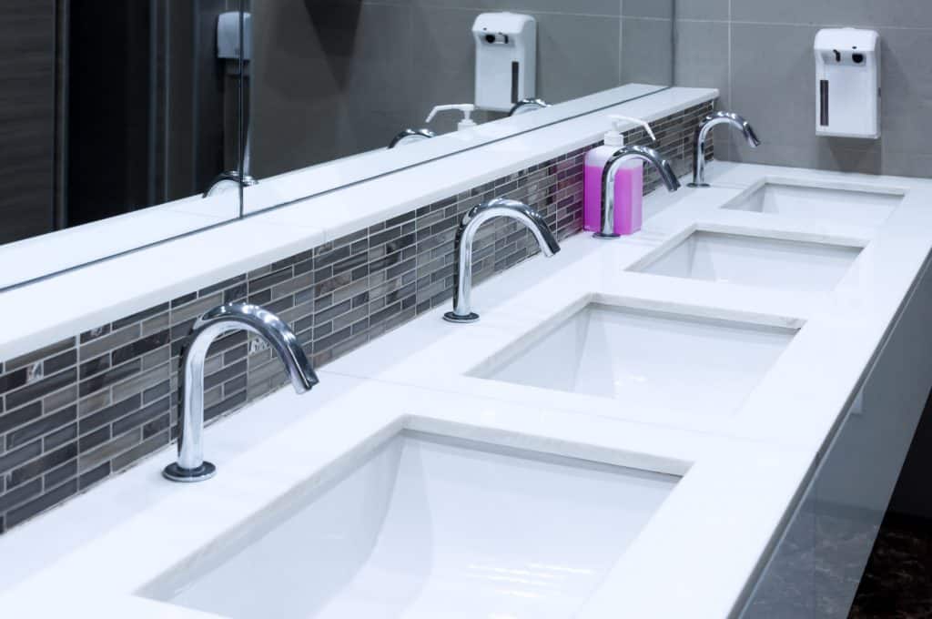 a Toilet sink interior of public toilet with of washing hands and mirror