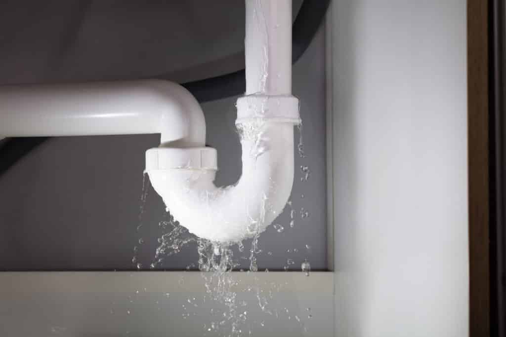 Close-up Of Water Is Leaking From The White Sink Pipe